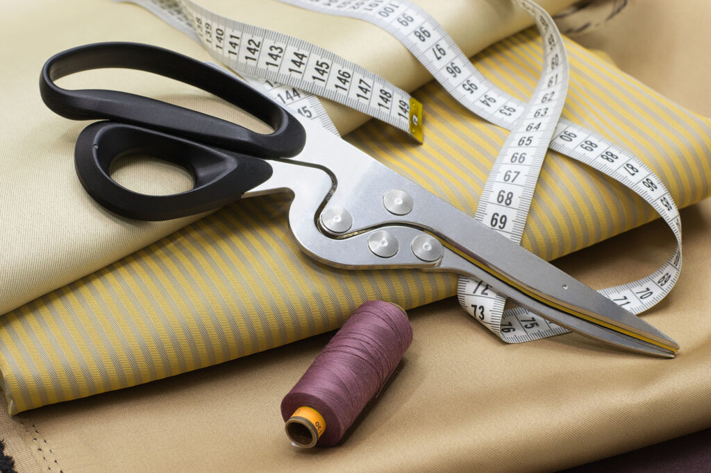 Scissors and measuring tape with clothing - custom tailoring photo