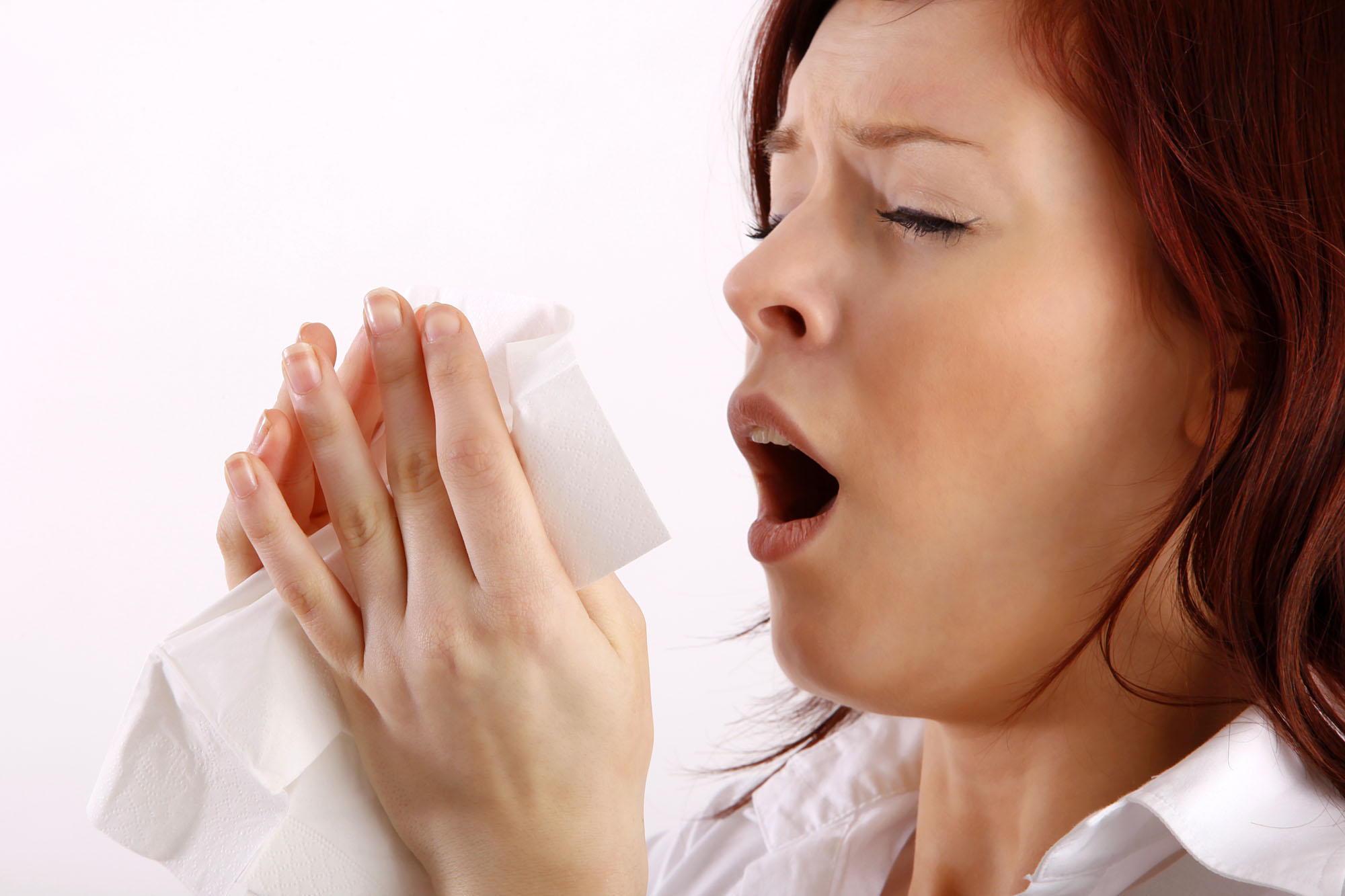 Woman sneezing due to allergens in the house